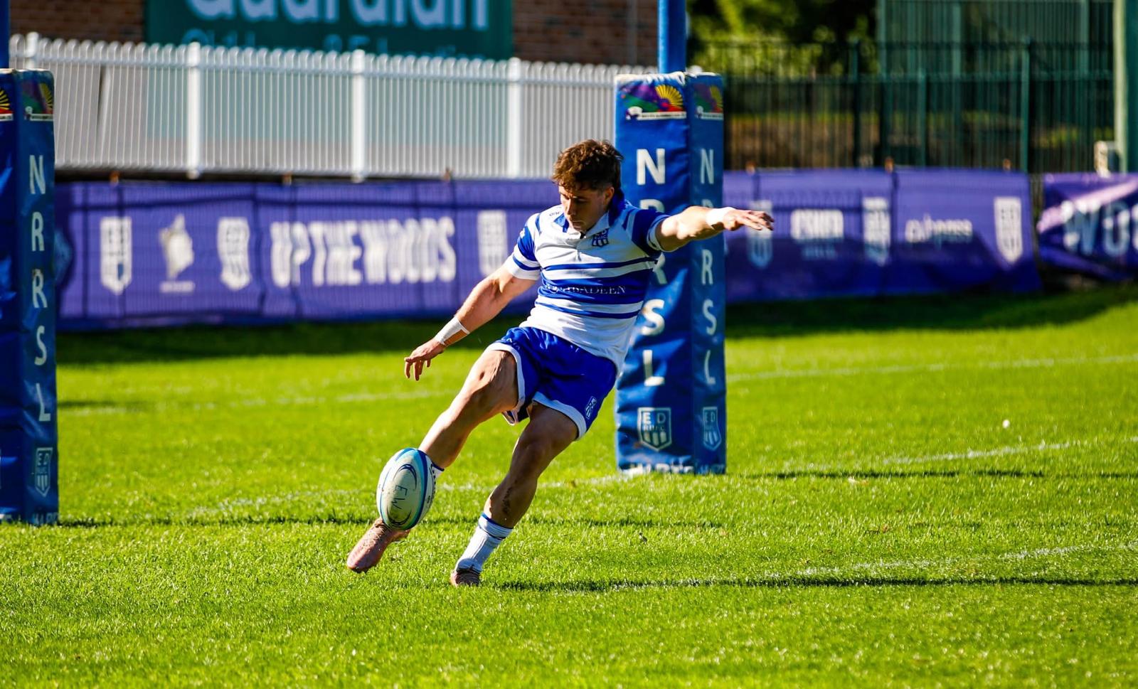 Tom Price kicking a rugby ball during a competitive match