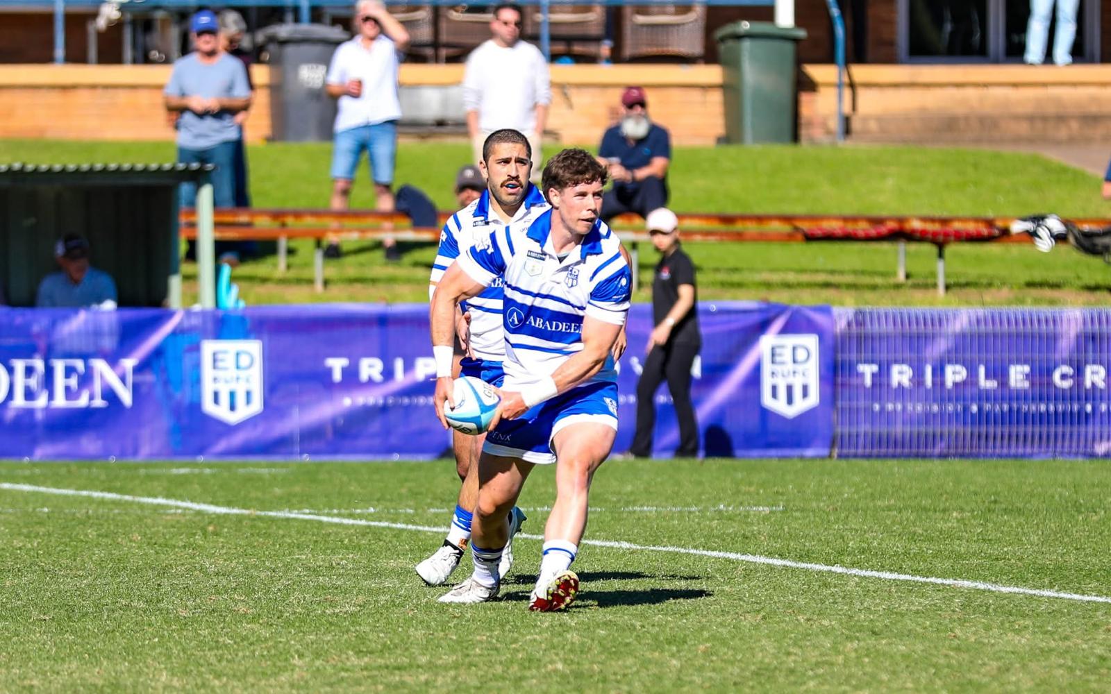 Tom Price carrying the ball in a competitive rugby match